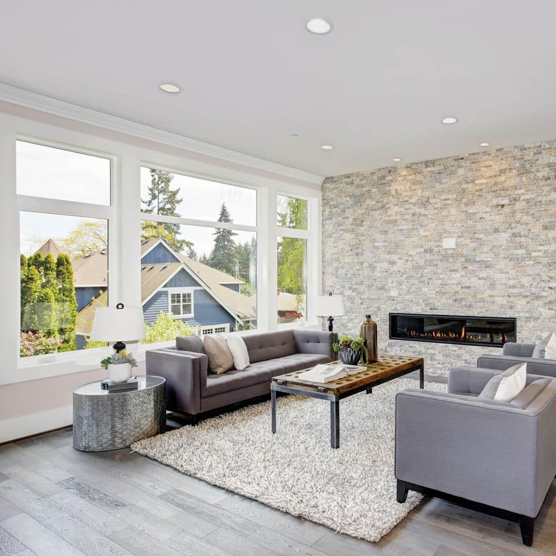 A living room with a large picture window with a casement window on either side.